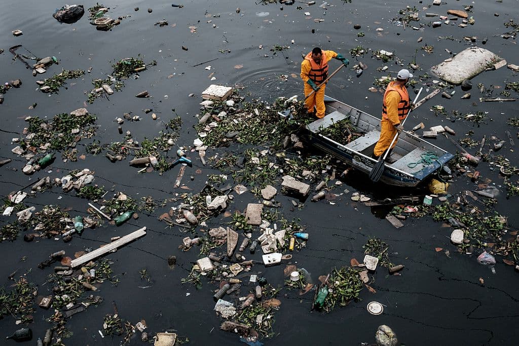 TOPSHOT - View of floating debris carried by the tide and caught by the "eco-barrier" before entering Guanabara Bay, at the mouth of Meriti river in Duque de Caxias, next to Rio de Janeiro, Brazil, on July 20, 2016. / AFP / YASUYOSHI CHIBA (Photo credit should read YASUYOSHI CHIBA/AFP/Getty Images)