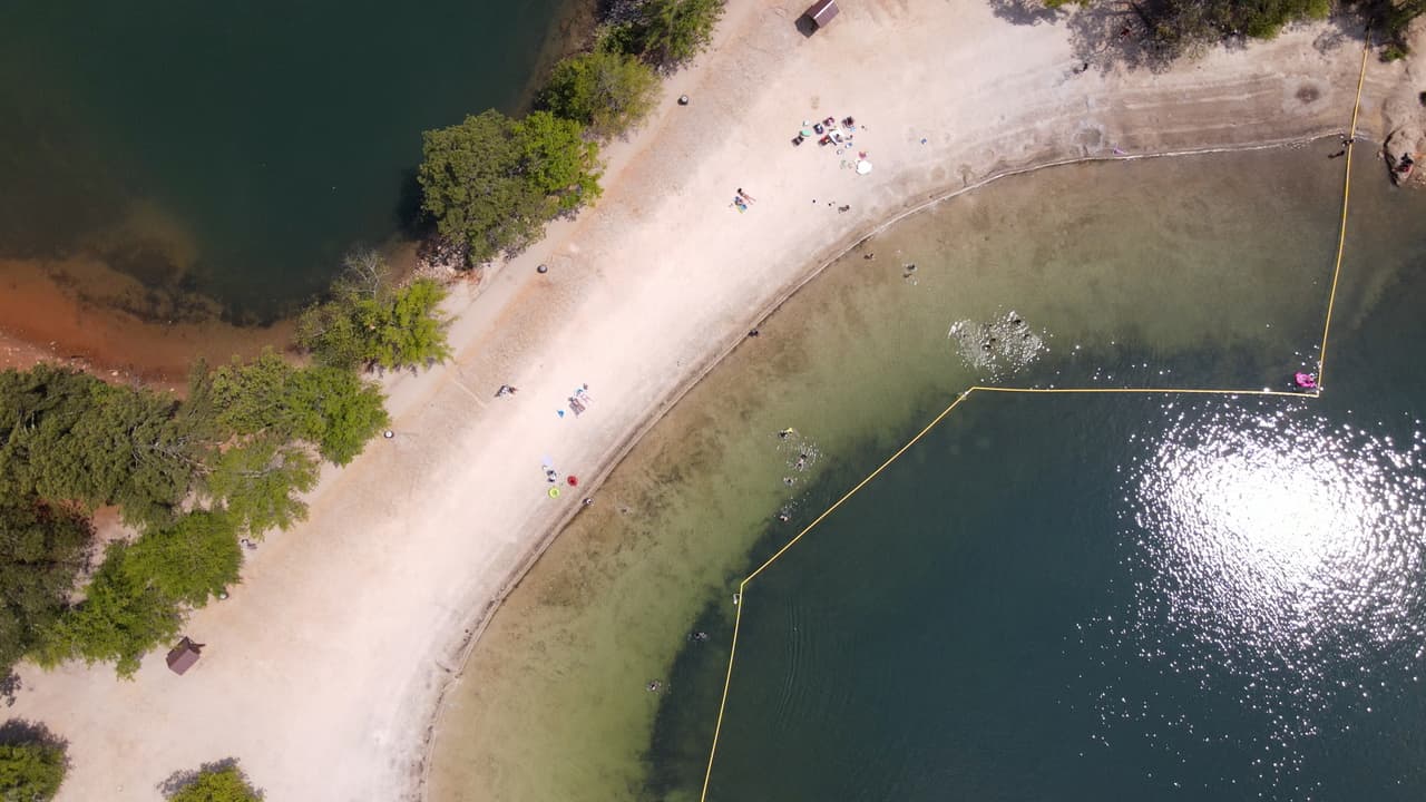 Los visitantes encuentran mesas y zonas de picnic cercanas a la playa de arena blanca.
