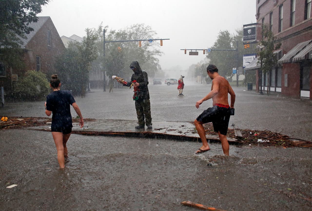 People survey the damage caused by Hurricane Florence on Front Street in downtown New Bern, N.C., on Friday, Sept. 14, 2018. (AP Photo/Chris Seward)