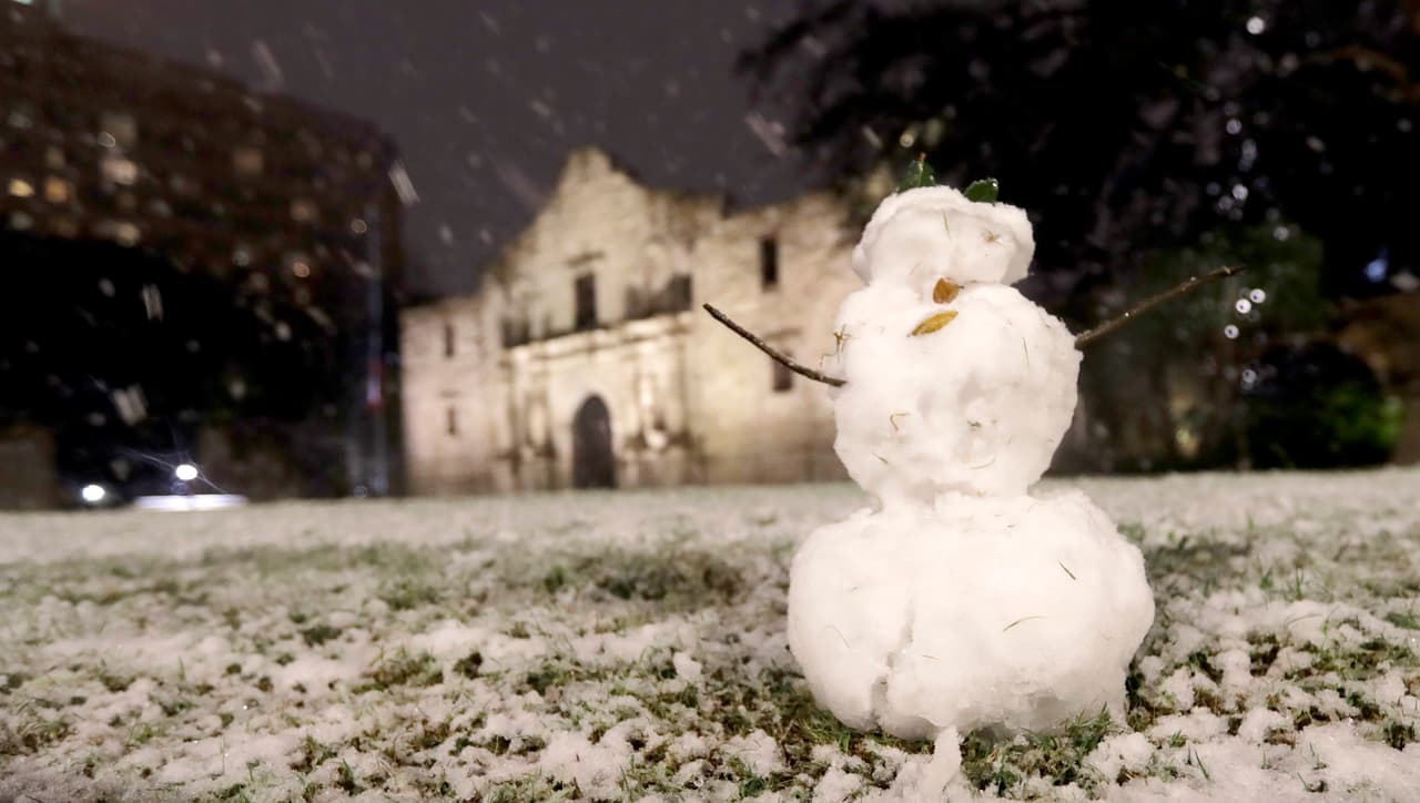 Los turistas que visitaban El Álamo durante la nevada construyeron un muñeco de nieve frente al monumento histórico.