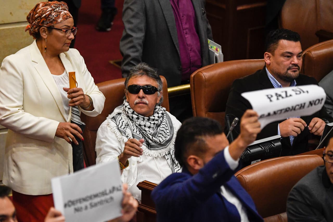 <b>El exguerrillero parlamentario buscado por EEUU.</b> Santrich, cuyo verdadero nombre es Seuxis Hernández, fue uno de los beneficiarios en marzo de 2018 de los 10 escaños en el parlamento asegurados para las Farc, parte del acuerdo de paz. Al mes siguiente fue arrestado por la Interpol al ser acusado de narcotráfico por una corte de Nueva York. La fiscalía general colombiana alegaba que los delitos por los que fue arrestado fueron posteriores a la firma del acuerdo de La Habana pero en mayo de 2019 una corte especial para el proceso de paz ordenó su liberación. Luego no se presentó a una audiencia judicial y desapareció.