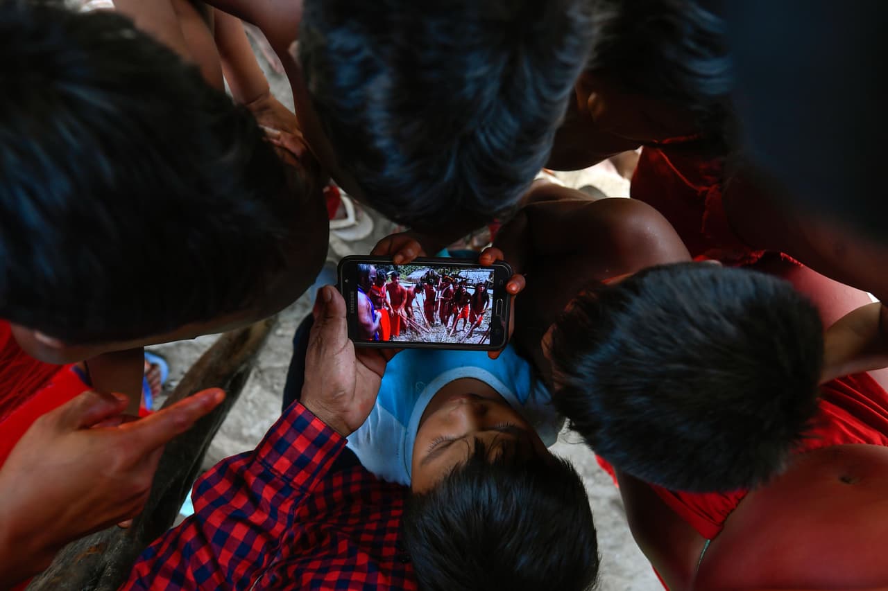 Niños se juntan para ver un video en un teléfono celular. (Foto de archivo)
<br>