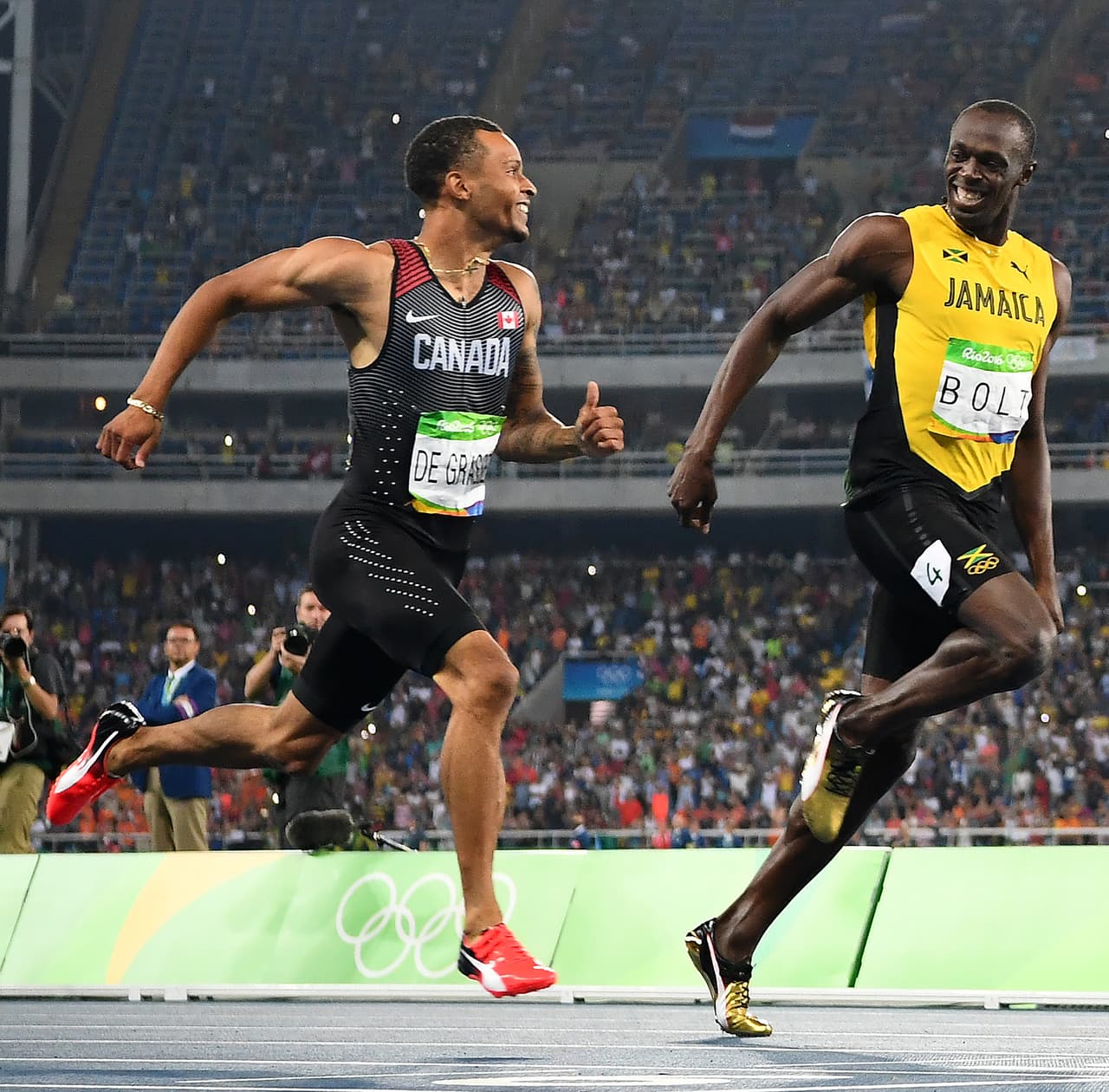 Usain Bolt bromea con Andre De Grasse (Canada) en la semifinal de los 200 metros.