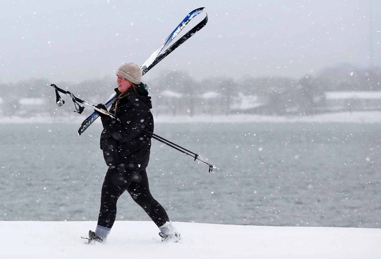 Foxfire Buck lleva carga su equipo de esquí después de esquiar a lo largo de la ensenada trasera en Portland, Maine.