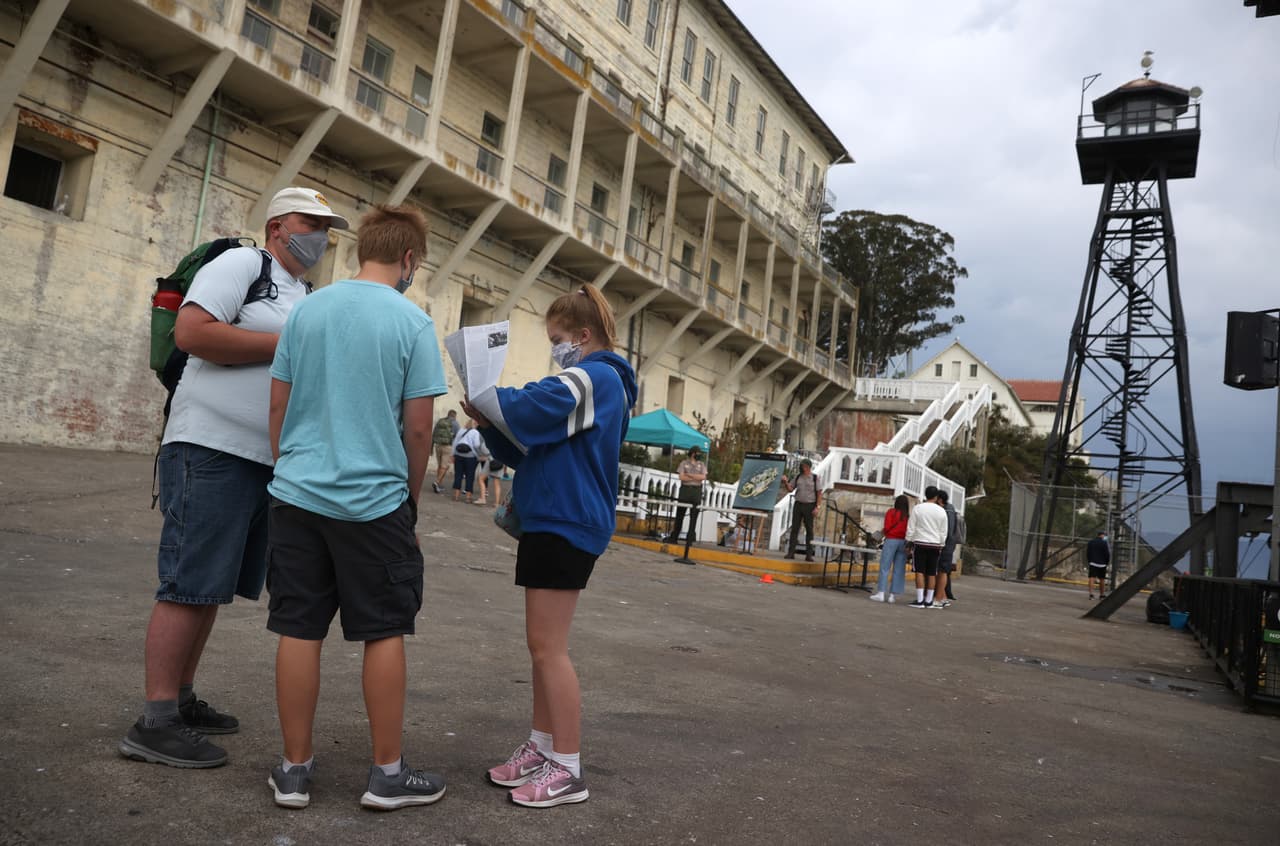 Algunos visitantes que acudieron este lunes revisan un mapa de la isla antes de recorrerla.
<b> Los tres llevan mascarillas </b>y en el sitio también se han implementado medidas de distanciamiento social para seguridad de los asistentes.