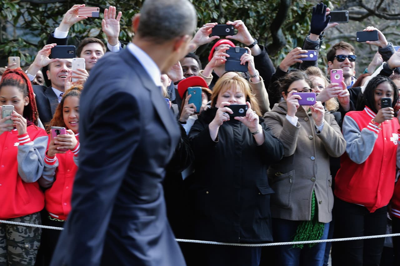 Visitantes captan al presidente de EEUU, Barack Obama, antes que éste parta a Jacksonville, Florida. (Foto por Chip Somodevilla).