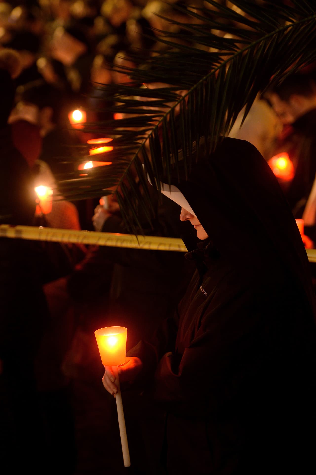 Una monja con una vela camina a través de la Via della Conciliazione, en una procesión anual en el Vaticano por las mujeres que sufren violencia doméstica. (Foto por Filippo Monteforte, AFP).