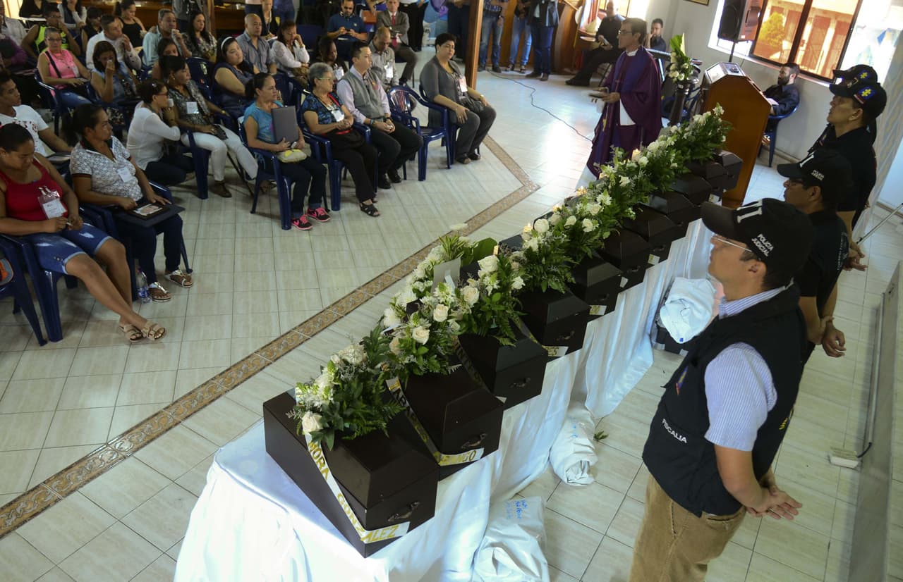 Familiares de 11 víctimas de la guerra civil colombiana asisten a una ceremonia donde recibieron los restos de sus seres queridos en Medellín. (Foto por Raul Arboleda, AFP).