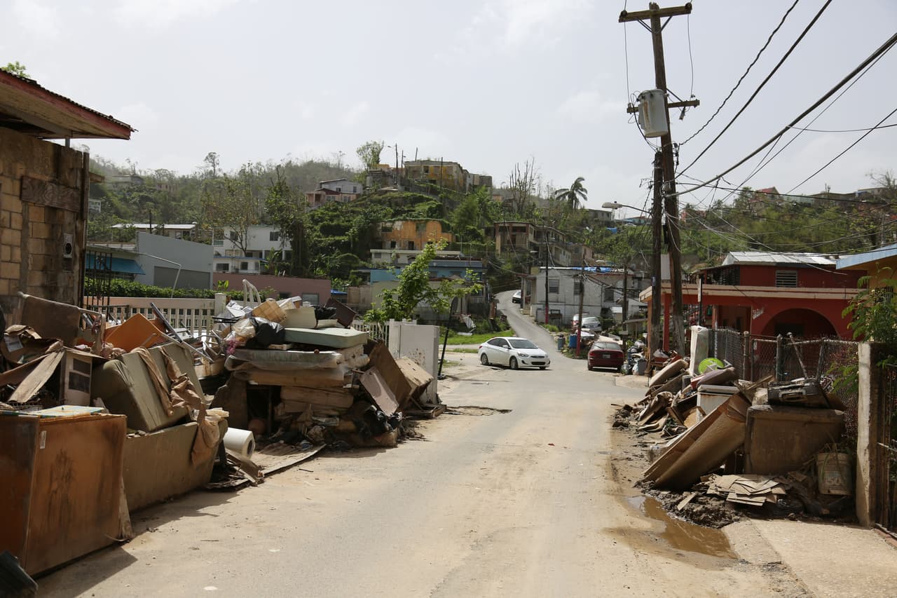 Muebles, camas, electrodomésticos y restos de viviendas continúan apiñados a los lados de las calles de Nuevo Londres y Judea, Utuado.