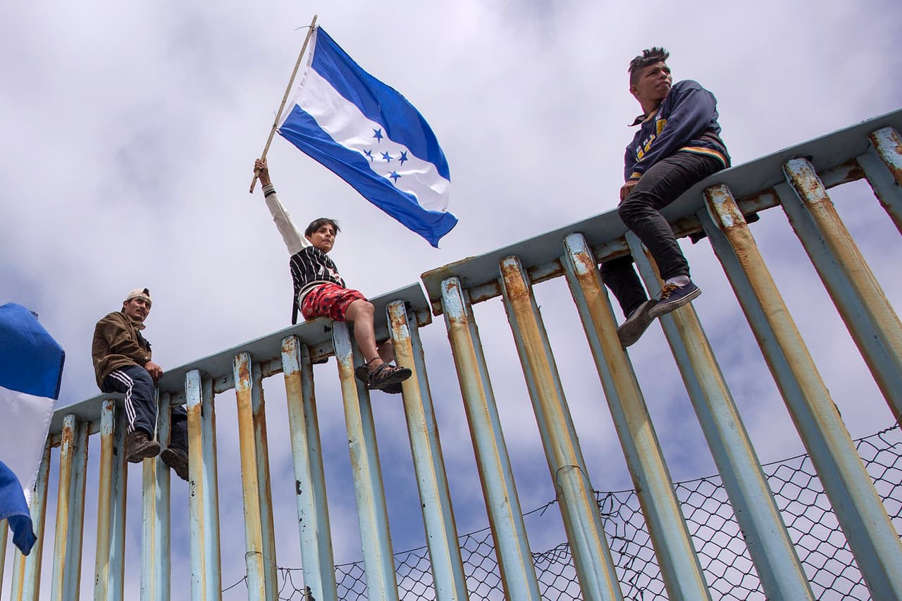 Cómo las banderas de Honduras en la valla fronteriza refuerzan el discurso antiinmigrante de Trump 