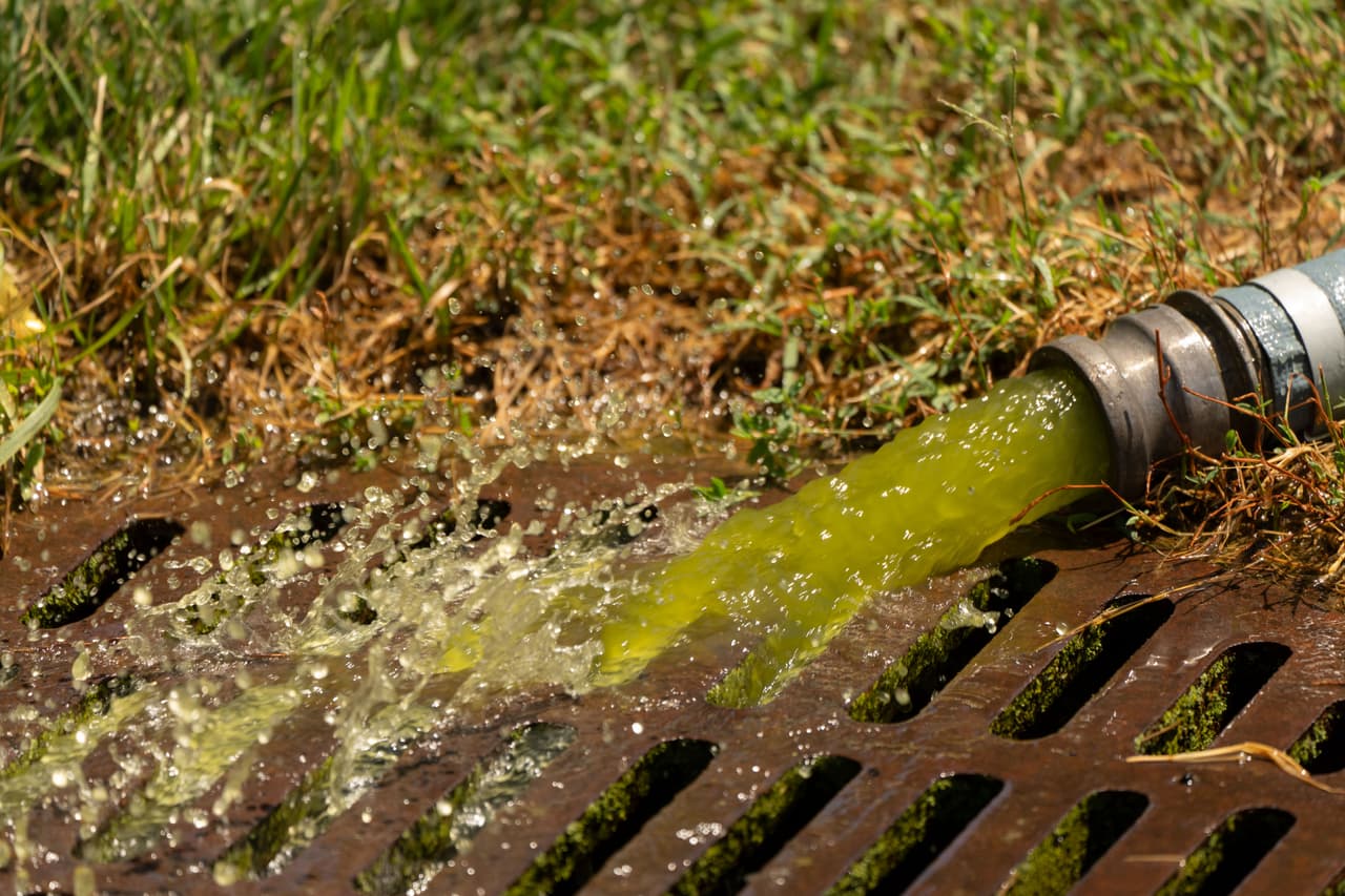 El agua de una manguera de vacío utilizada por empleados del Servicio de Parques Nacionales para limpiar el estanque reflectante del Monumento a Lincoln cae en un desagüe cercano.
