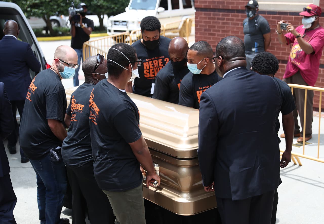Un grupo de hombres cargan féretros con los restos de Rayshard Brooks para ingresar a la Iglesia Bautista Ebenezer. Brooks fue asesinado el 12 de junio por un oficial de policía de Atlanta después de una lucha durante una prueba de sobriedad en el estacionamiento de un restaurante de Wendy's.