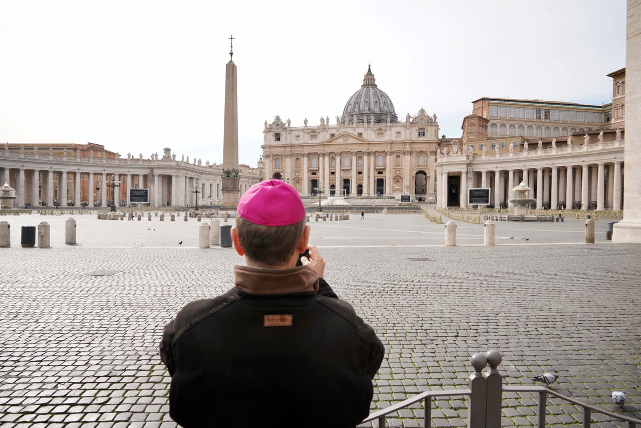 Un prelado toma una foto de una plaza vacía de San Pedro, en Roma, este martes 10 de marzo. Este es un sitio que suele estar atestado de turistas. En el Vaticano la vida también se ha detenido y la inmensa basílica de San Pedro, meta del turismo mundial, está cerrada.