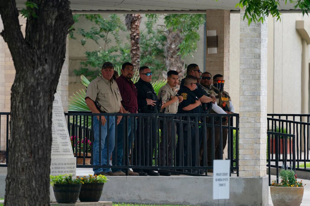 El personal policial en la entrada de la iglesia esperó la llegada de los féretros con los cuerpos de Irma García y su esposo, Joe.