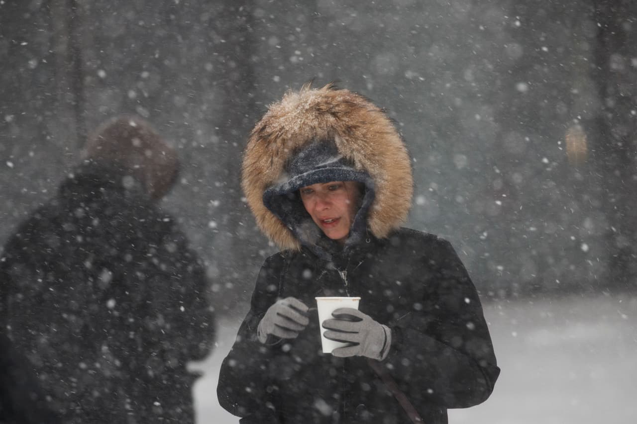 Mujer camina con una bebida caliente hacia la estación del Subway Atlantic Avenue-Barclays Center en Brooklyn.