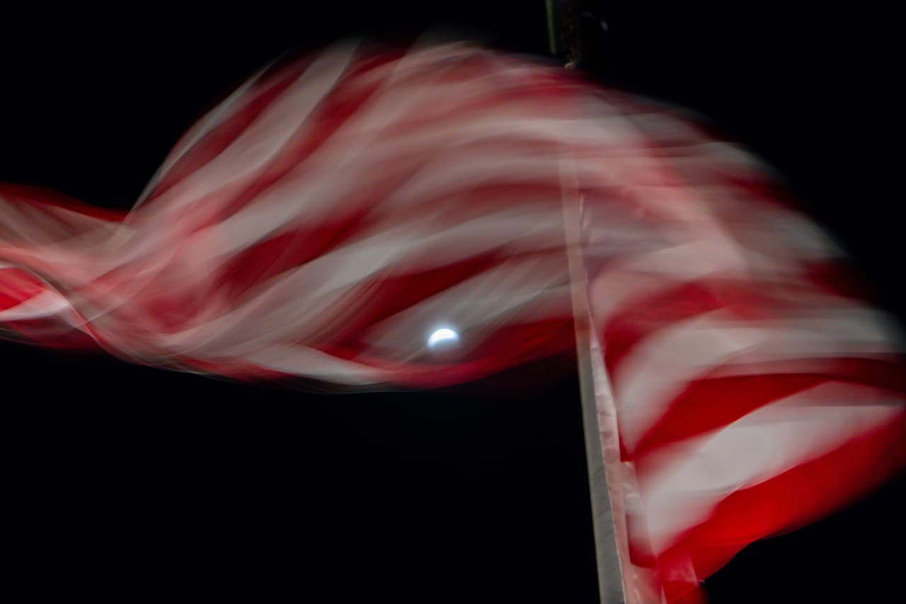 Un eclipse lunar parcial, visto a través de una bandera estadounidense, el 28 de agosto de 2026, en Washington.