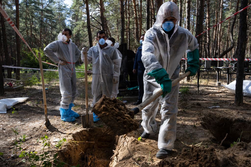 Forenses y equipos de rescate trabajan en recuperar los cuerpos hallados a las afueras de Izium.