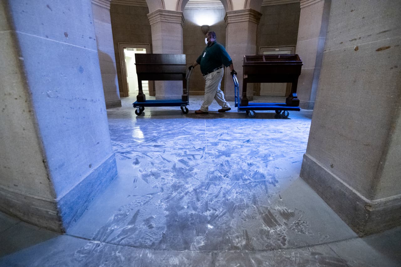Un empleado del Congreso traslada unos muebles dañados por la turba. El piso del icónico edificio se ve cubierto del polvillo que deja las bombas de gas lacrimógeno.
<br>