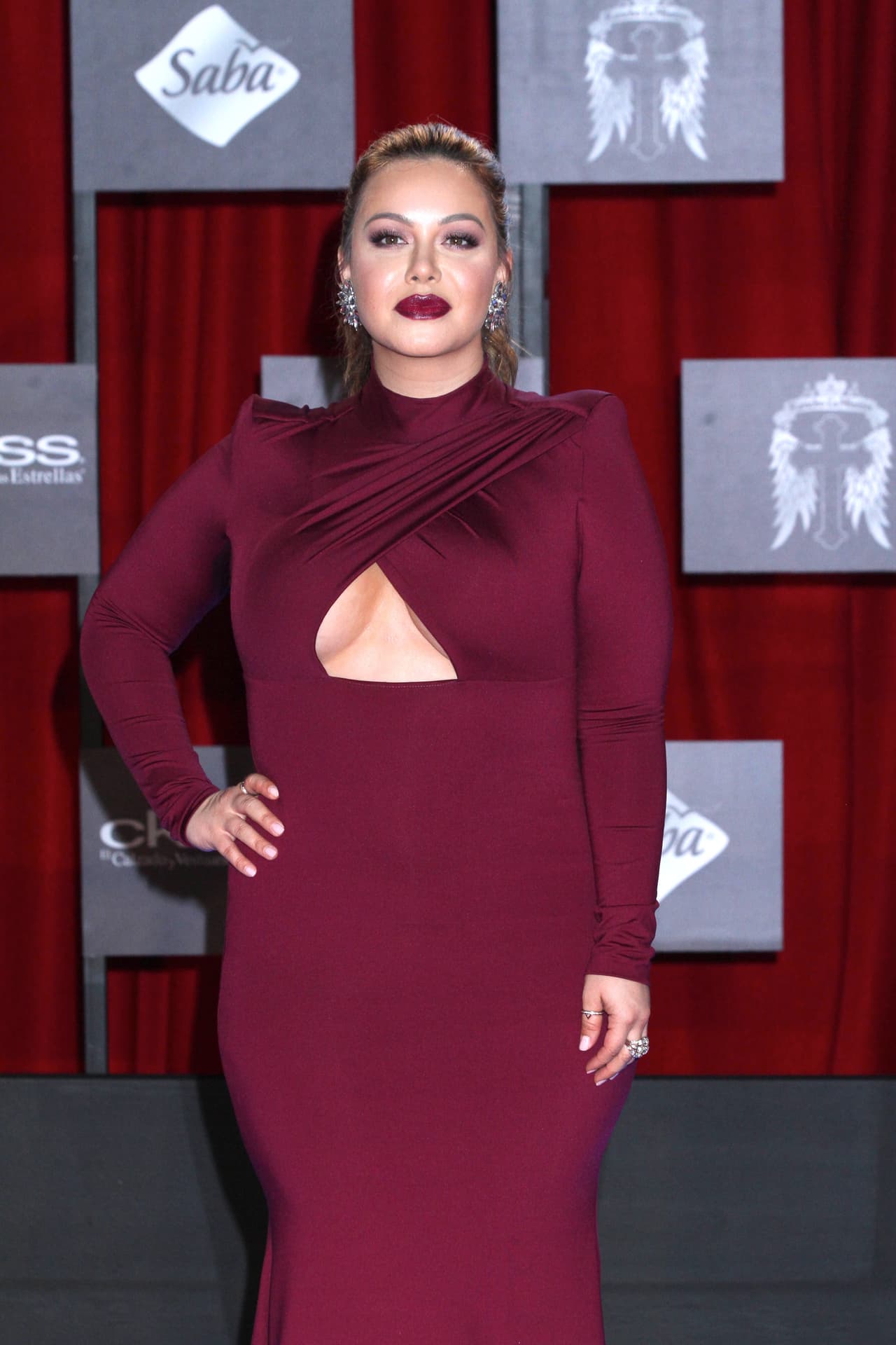 En esta ocasión, un corte en triángulo a la altura del pecho rompió con la monotonía del vestido que combinaba con su labial. Los vestidos con cortes a lo largo del cuerpo fueron una fuerte tendencia en 2015.