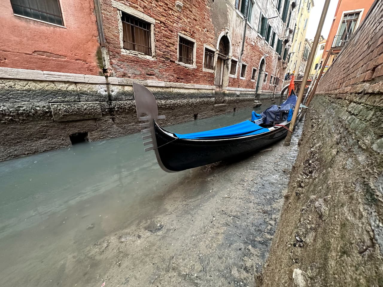 Una góndola en un canal seco en Venecia, este lunes 20 de febrero. La marea baja ha afectado los paseos turísticos de la ciudad, puesto que es imposible navegar por algunas de sus principales arterias.