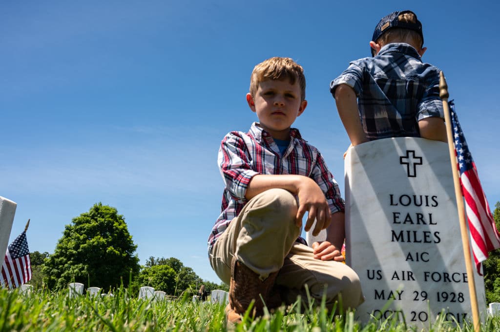 Henry Dennis (izq.) y Samuel Dennis (der.) junto a la tumba de sus bisabuelos después de una ceremonia del 'Memorial Day' en el Cementerio de Correos Principal de Fort Knox el 31 de mayo de 2021 en Fort Knox, Kentucky. El cementerio aloja a 967 militares estadounidenses, personal extranjero, dependientes civiles, prisioneros de guerra y desconocidos. 
<b>Ahí se conmemoró el centenario</b> del primer soldado enterrado en el cementerio en 1921.