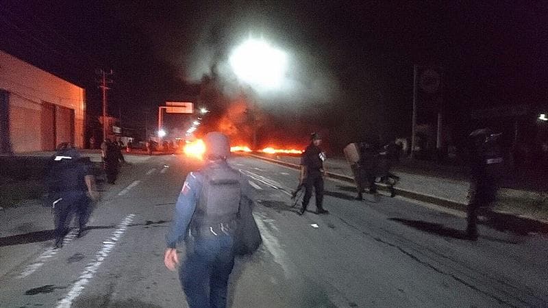 Policías replegando a un grupo de manifestantes que mantenían un bloqueo en carretera federal transistmica 185, en Salina Cruz