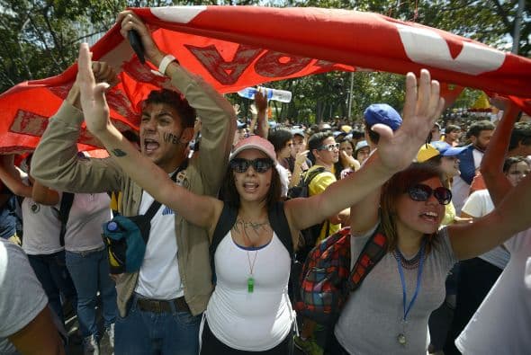 Los estudiantes desarmados portan banderas durante la demostranción contra el régimen de Nicolás Maduro. Los estudiantes llevaron a cabo una manifestación pacífica contra el régimen del mandatario Nicolás Maduro el 12 de febrero de 2014. Motorizados uniformados y con sus caras cubiertas, dispararon contra los manifestantes, matando a dos estudiantes y a un oficial.