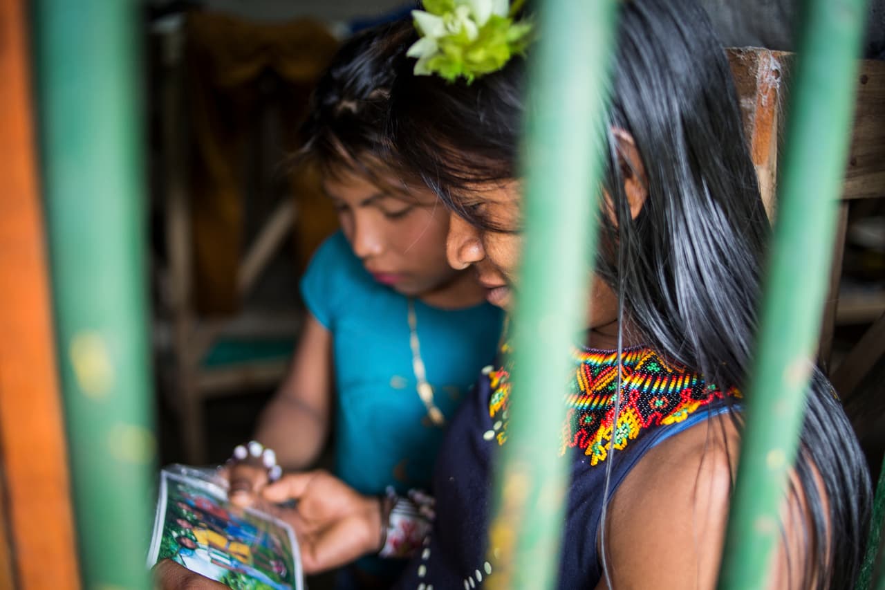Mariana enseña una foto a una de sus compañeras en el 'cuartel' donde viven.