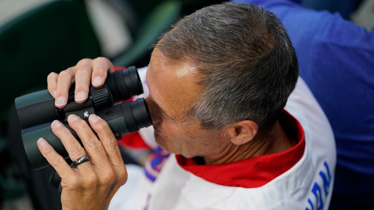 Un aficionado utiliza binoculares para observar la práctica de bateo antes del Juego 1 de la Serie Mundial de béisbol entre los Arizona Diamondbacks y los Texas Rangers el viernes 27 de octubre de 2023 en Arlington, Texas.