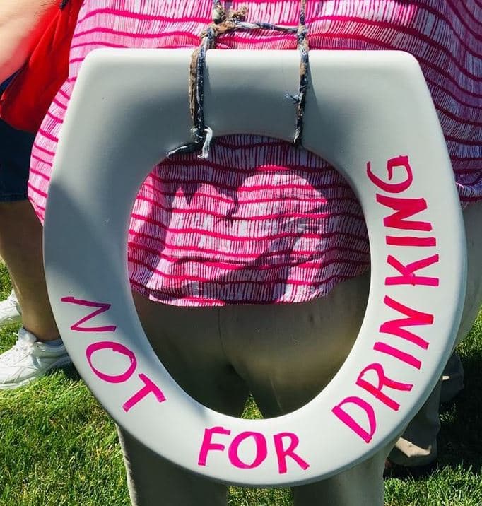 Esta pancarta fue inspirada en las fuertes declaraciones que hizo la congresista Alexandria Ocasio-Cortez, quien a través de su cuenta de Twitter dijo: “No son sólo los niños. Es toda la gente bebiendo de las tazas del baño, y oficiales riéndose frente a los miembros del Congreso”.
<br>