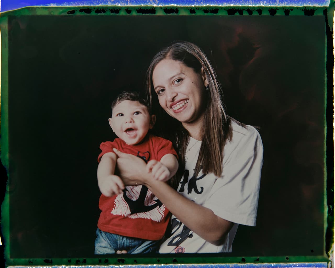 Daniele Ferreira dos Santos sonríe mientras sostiene a su hijo Juan Pedro. El padre del pequeño los dejó a las pocas semanas de haber nacido Juan. Madre y bebé compensan su ausencia con el apoyo de la abuela y la hermana mayor, que se turnan para cuidarlo.