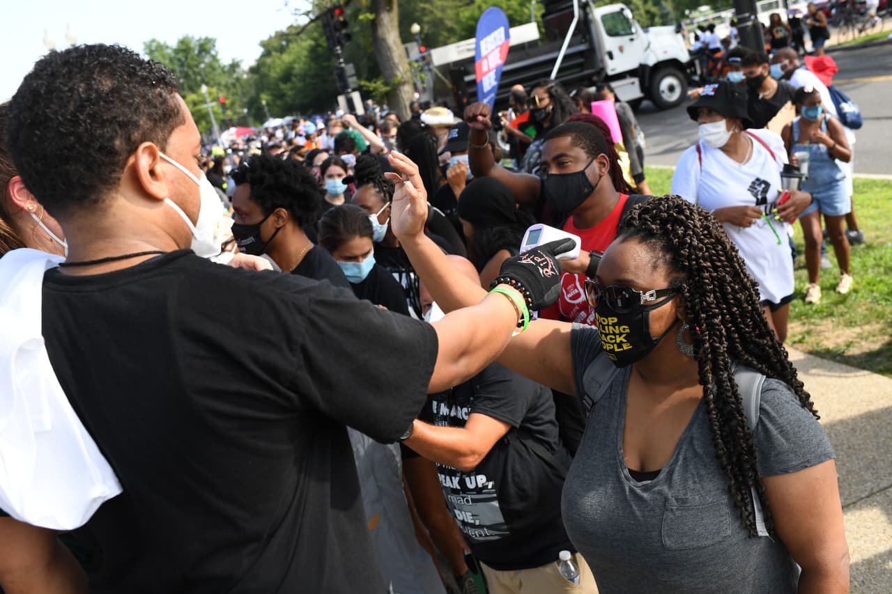 Varios miles de asistentes hicieron fila con mascarillas para protegerse del coronavirus y se tomaron la temperatura antes de entrar a la zona de la concentración.
