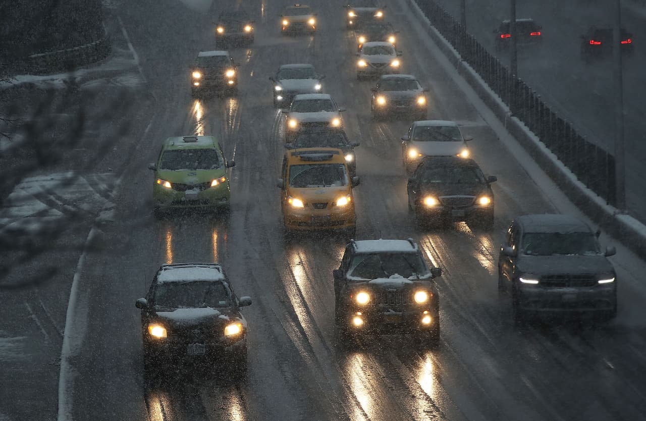 Los autos conducen por una vía nevada en Brooklyn, Nueva York. Autoridades piden a los residentes de ese estado, Nueva Jersey y Connecticut mantenerse en sus hogares y cargar los celulares.