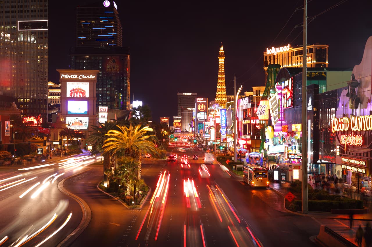 "Las Vegas, USA - April 9, 2011: Traffic blurs along the Las Vegas strip. Monte Carlo casino on left, shops and Paris\' Eiffel tower on right."
