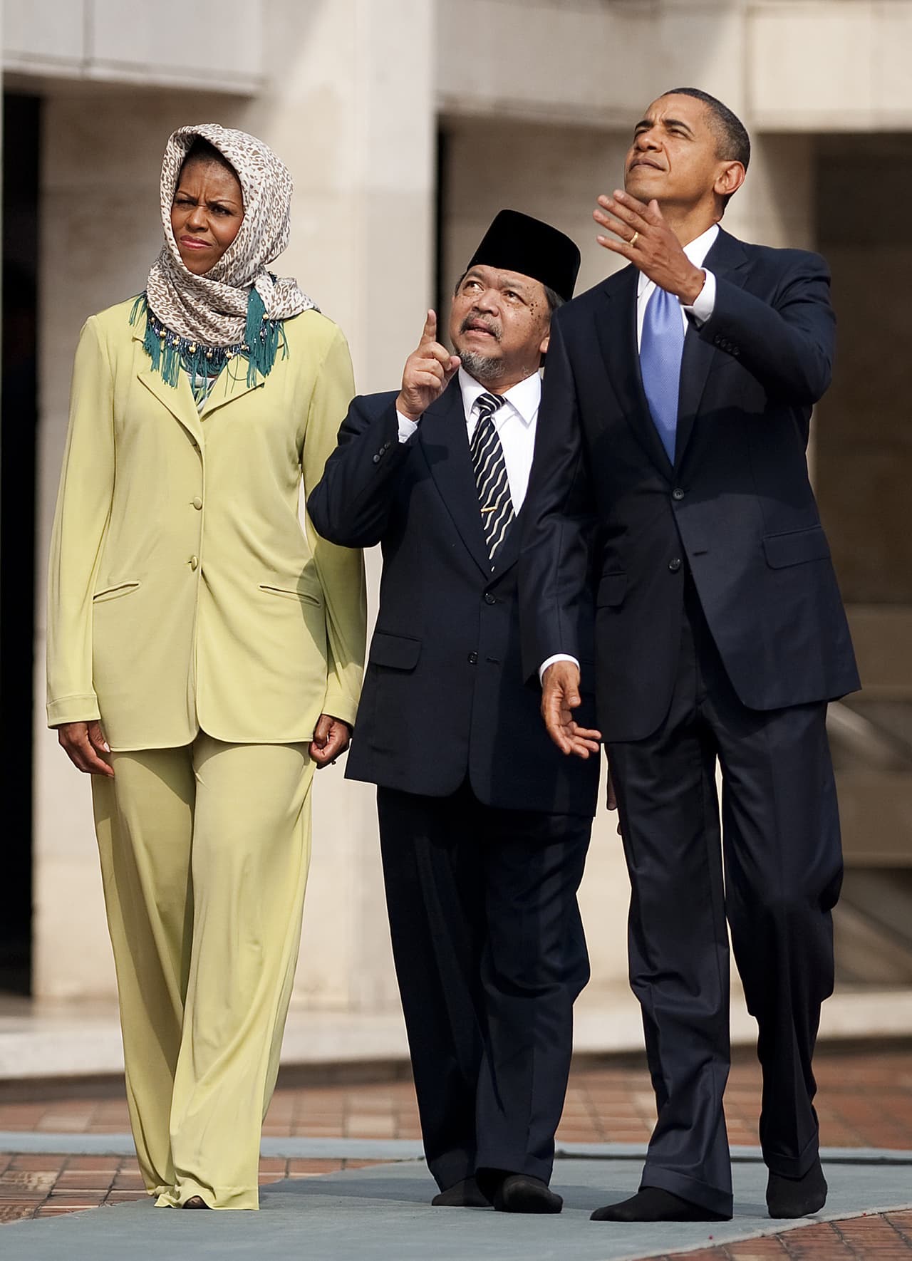 Michelle llevó un traje pantalón de Stephen Burrows, diseñador afroamericano de Harlem. En la imagen pasea por el templo Istiqlal Mosque, en Jakarta con el gran imán de la mezquita, Grand Imam Yaqub, y con Barack Obama.