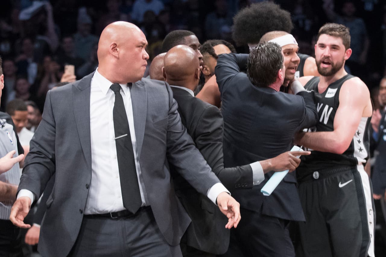 El entrenador de los Brooklyn Nets Kenny Atkinson (centro) trata de controlar a su jugador Jared Dudley (segundo de derecha a izquierda) durante la bronca.