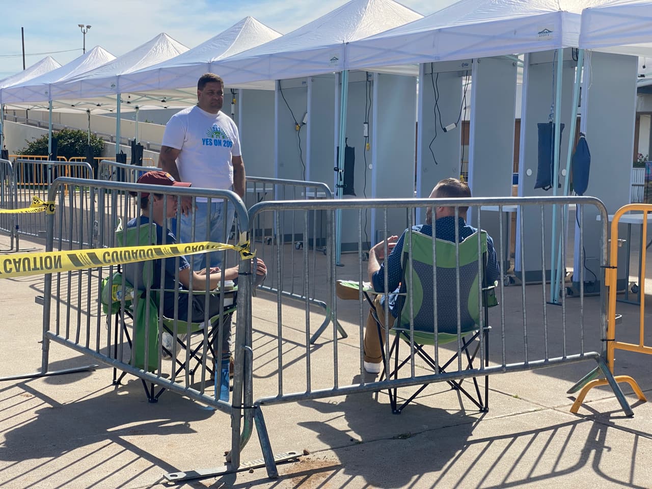 Un grupo de personas esperan en línea el ingreso al Veterans Memorial Coliseum en Phoenix para escuchar al candidato Bernie Sanders.
