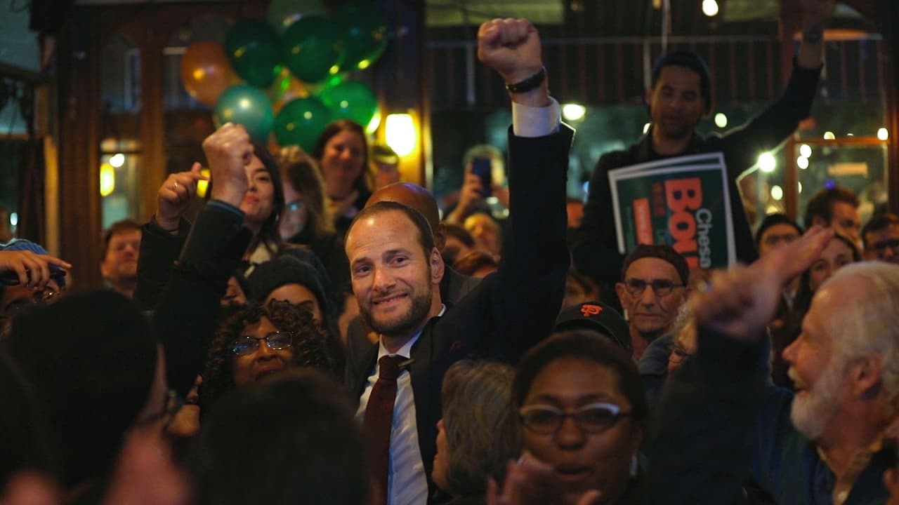 El fiscal electo de San Francisco alza la mano en señal de victoria durante la celebración con sus simpatizantes.