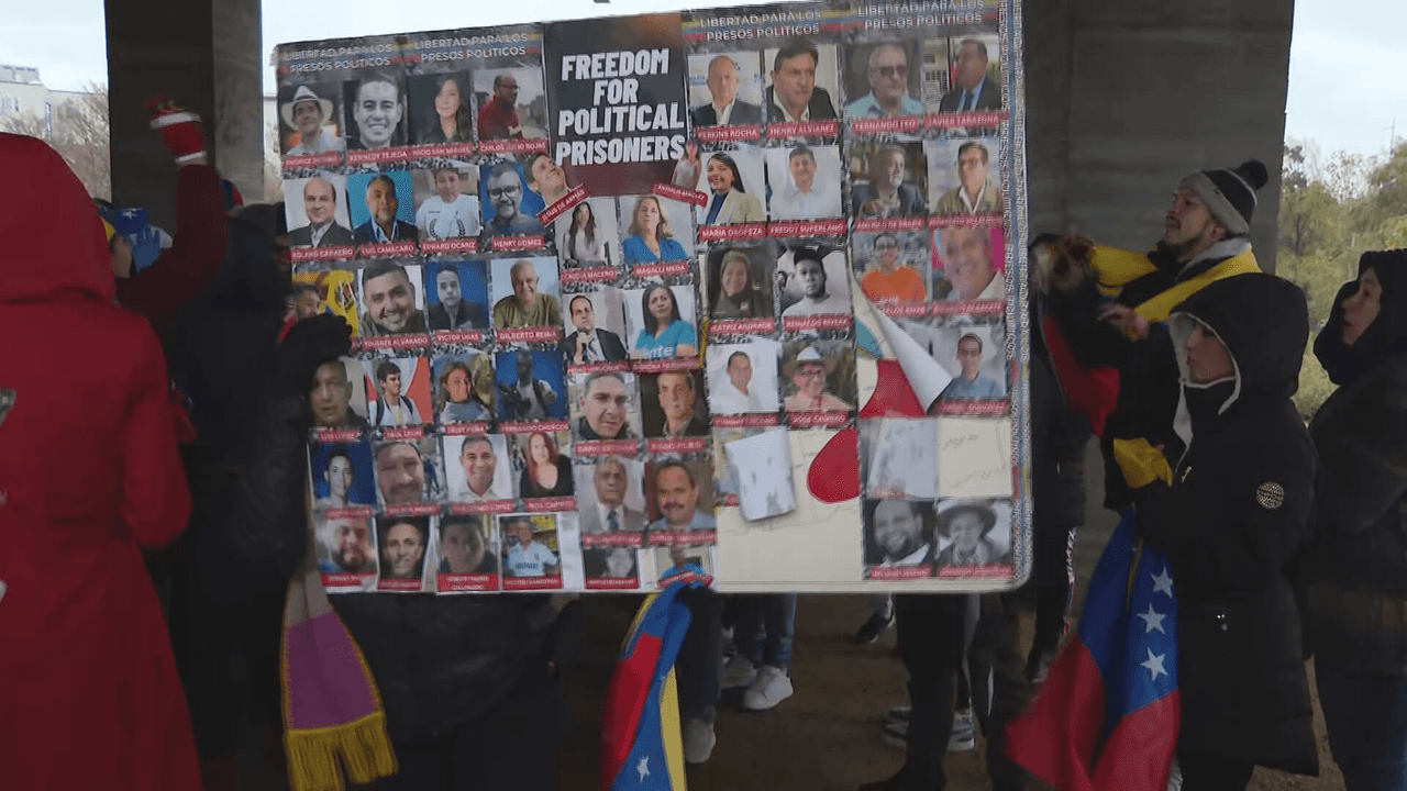 La comunidad llevó una pancarta grande con fotografías de quienes dicen son prisioneros políticos en el país.