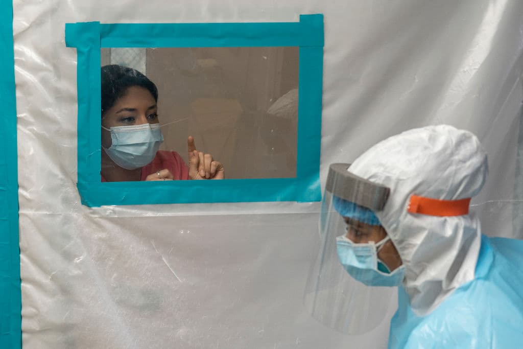 Las autoridades texanas han reportado más de 14,000 nuevos casos de coronavirus el miércoles, un día antes del Día de Acción de Gracias, lo que supone un nuevo récord de contagios diarios en el estado desde que inició la pandemia. En la imagen, dos trabajadores médicos se comunican a través de un esaci