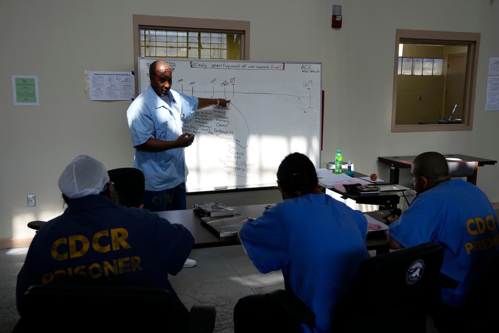 La controversia se intensifica debido a la falta de transparencia en el proceso. Críticos señalan que el consejo asesor de 21 miembros, designado por Newsom para dar forma al diseño y programa de las instalaciones, no está sujeto a las leyes de reuniones abiertas. En la foto el mentor Harry Goodall dirige una discusión sobre historia en el Programa de mentores de alfabetización entre pares para hombres encarcelados durante una gira de prensa en la prisión estatal de San Quentin, California, el 26 de julio de 2023.