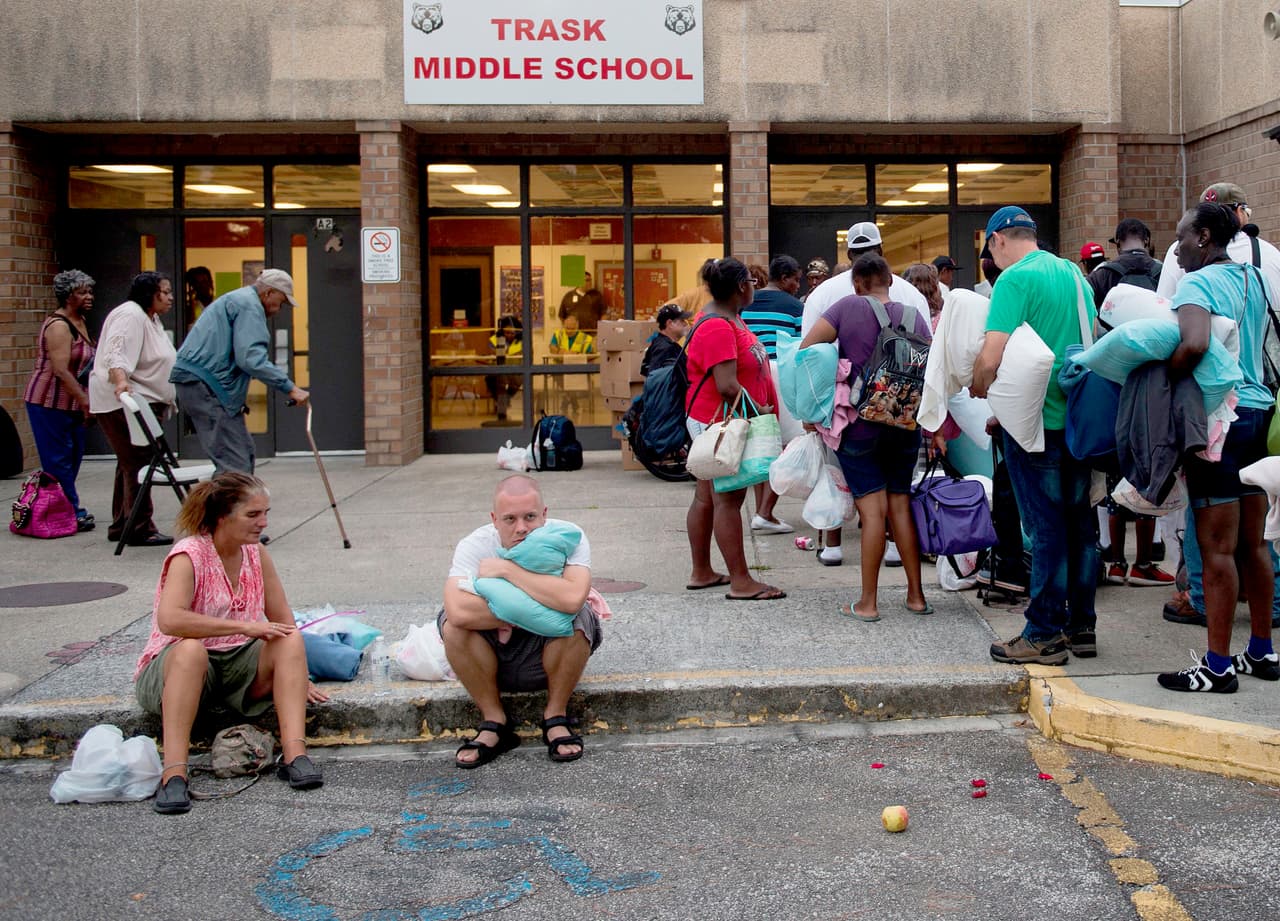 Decenas de personas hacen fila para ingresar a en la escuela secundaria Trask en Wrightsville Beach, Carolina del Norte, preparada como refugio. Más de un millón de personas en Carolina del Norte, Carolina del Sur y Virginia han recibido orden de evacuación.