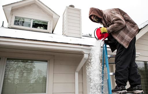 Este hombre de Spring, Texas, recoge la nieve que se acumuló en el tejado de su casa para tratar de armar un muñeco.