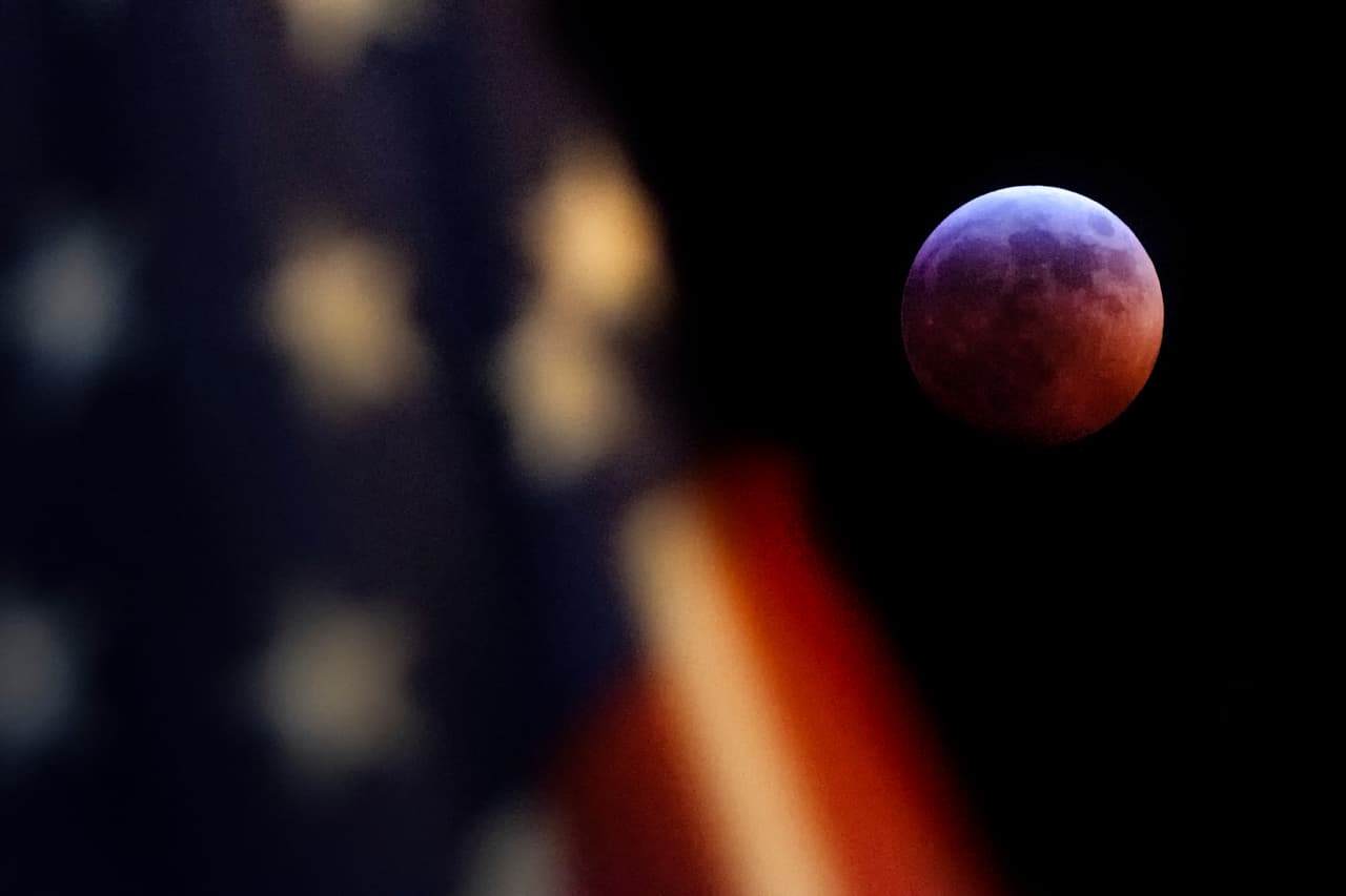 Una bandera de Estados Unidos ondea en Washington durante el eclipse lunar que comenzó en la noche del 20 de enero de 2019.