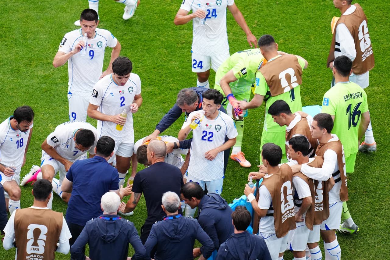 Jugadores de Uzbekistán se reúnen durante una pausa para hidratación durante el partido de fútbol del Grupo K de la Copa Mundial entre Portugal y Uzbekistán