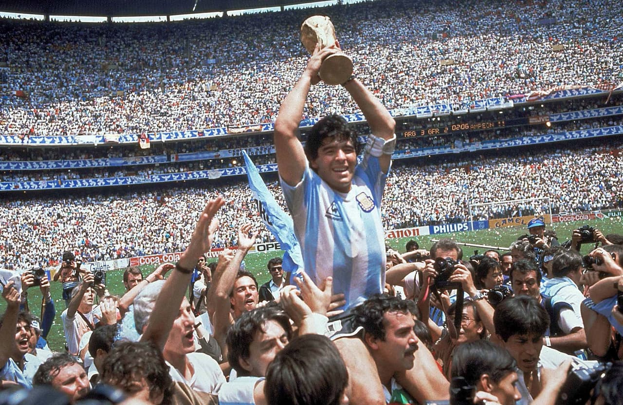 En esta foto de archivo del 29 de junio de 1986, Diego Maradona levanta el trofeo después de que Argentina derrotara a Alemania por 3-2 en la final de la Copa Mundial en la Ciudad de México. En este partido, la leyenda del futbol argentino fue protagonista de dos de los goles más históricos: la "Mano de Dios" y el "Gol de Oro".