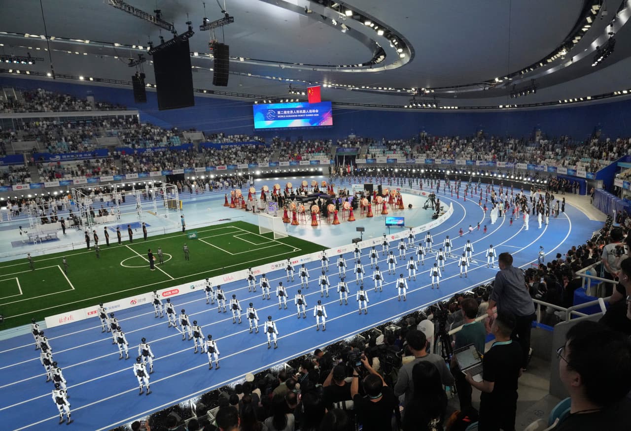 Robots con apariencia de espectadores realizan una exhibición durante la ceremonia de apertura de los Juegos Mundiales de Robots Humanoides en Pekín.