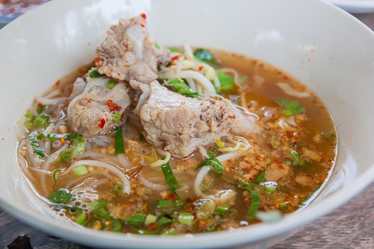 Corta la carne de cerdo en cubos y cocela en una olla con raíz de apio. Aparte en un sartén grande añade el aceite de oliva, cebolla picada, zanahoria rallada, apio, chirivía y pimiento picado, cocina a fuego lento por 10 minutos. Añade las dos mezclas y deja al fuego para servir no olvides el toque de perejil.