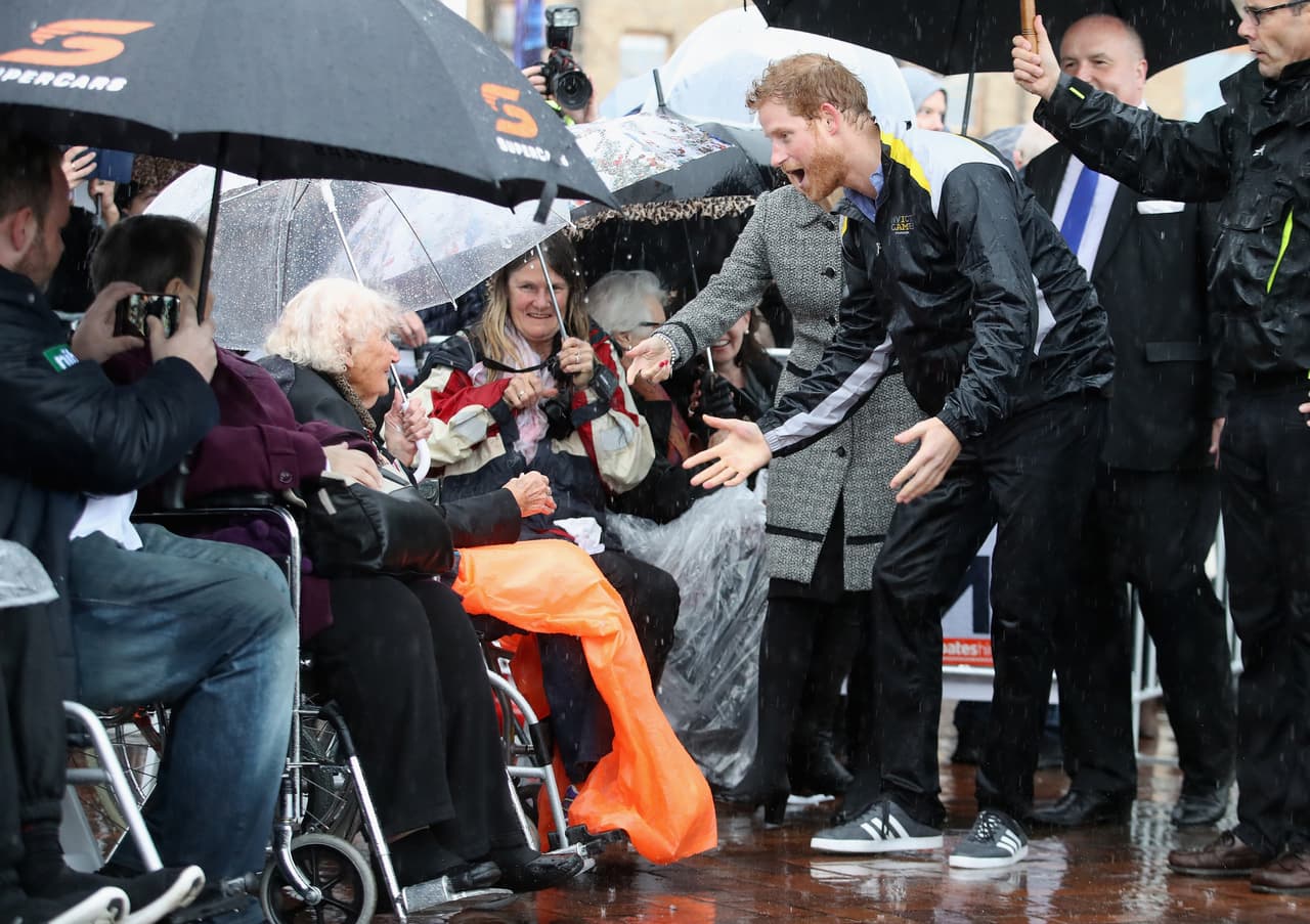 Al momento de verla en primera fila esperando bajo la lluvia, el Príncipe Harry rompió los protocolos y corrió para abrazarla fuertemente.