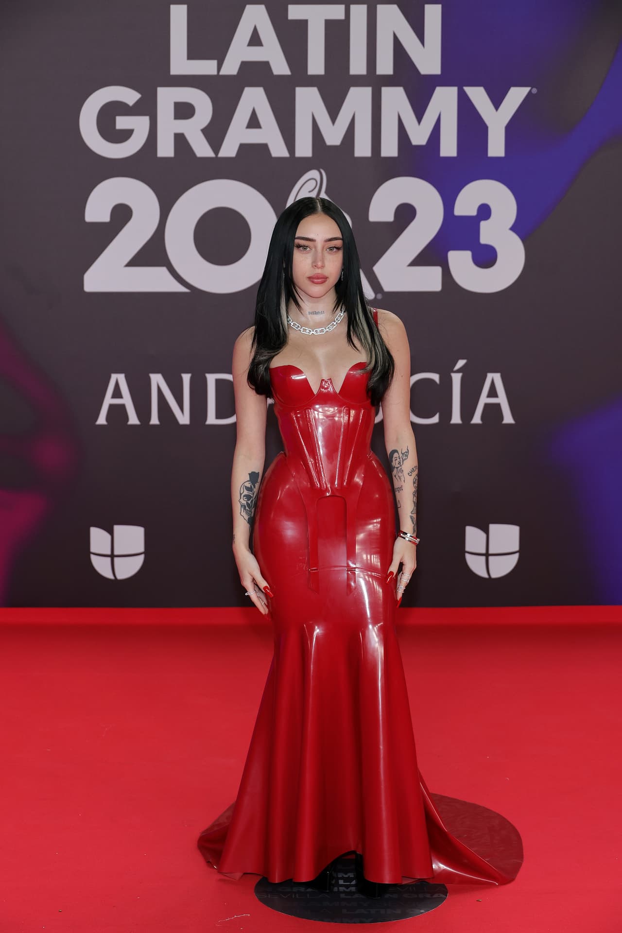 <b>Nicki Nicole</b> se engalanó en un vestido rojo, con un estilo corset en la parte superior y una falda de sirena.